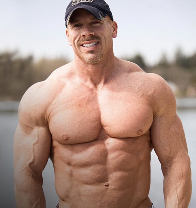 Muscular man outdoors wearing a cap.