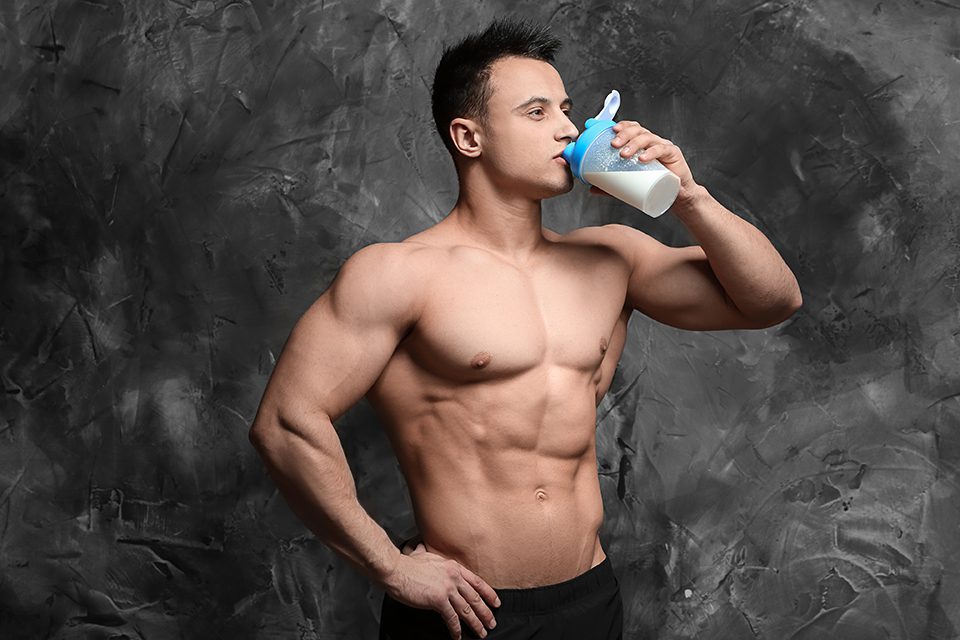 Muscular man drinking protein shake, fitness lifestyle concept.